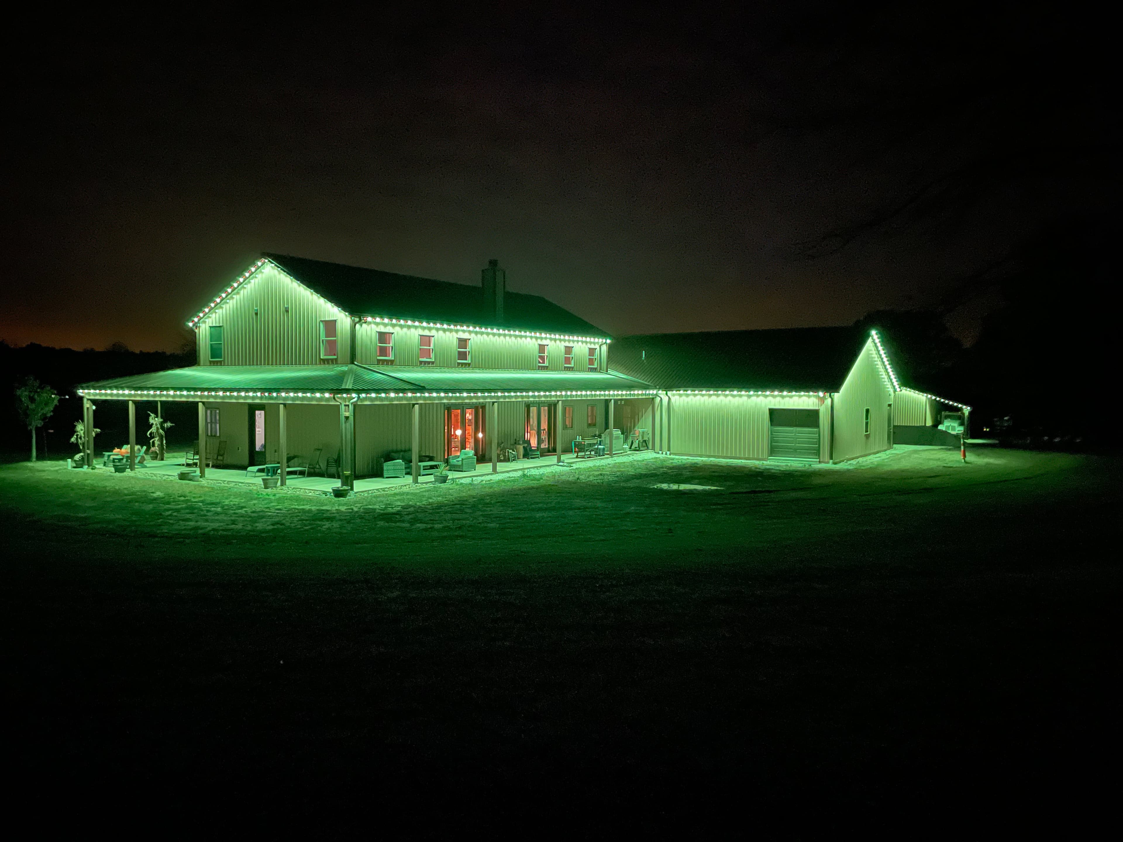 Large two-story Halton home with permanent green LED outdoor lighting along every roofline at night