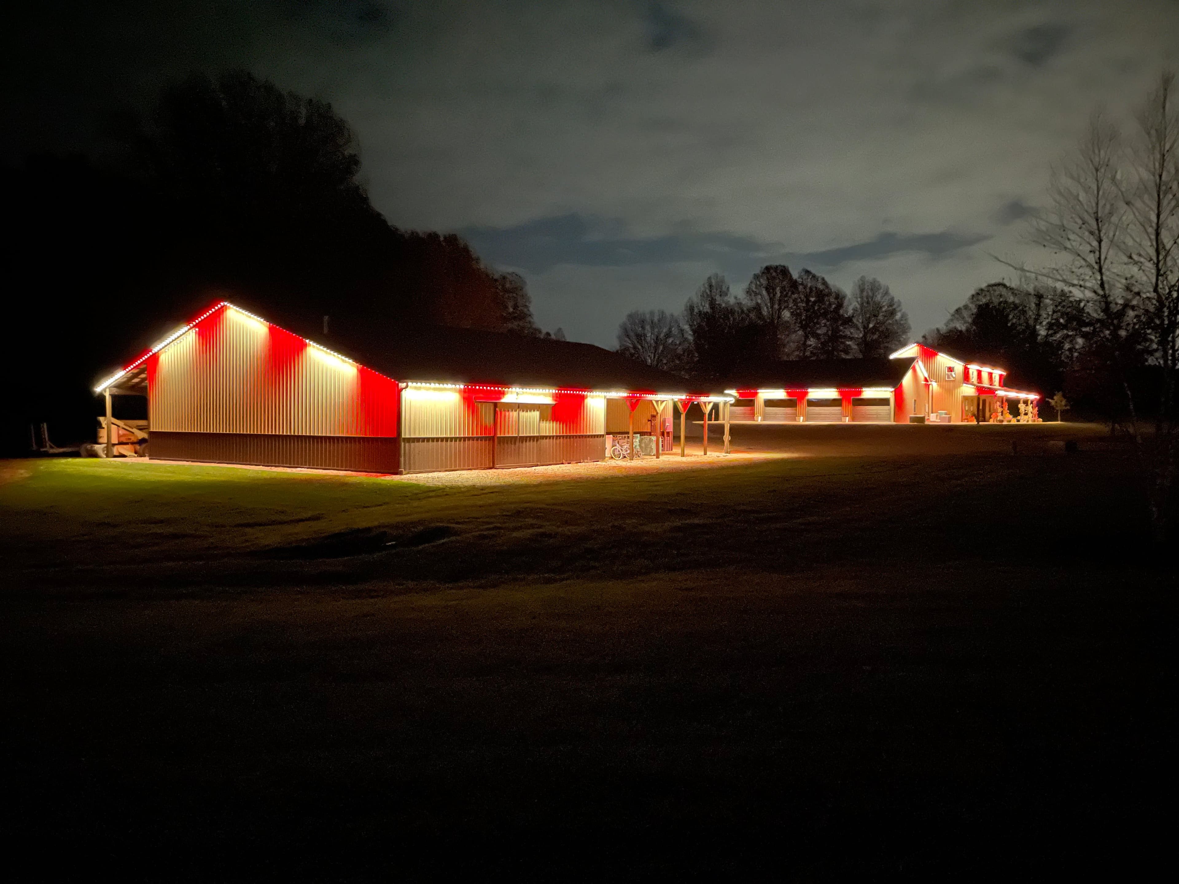 Permanent LED roofline lighting set to red on a luxury Halton property at night